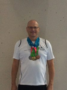Graham with his full Backstroke medal set; gold, silver, bronze (and one more for his IM)